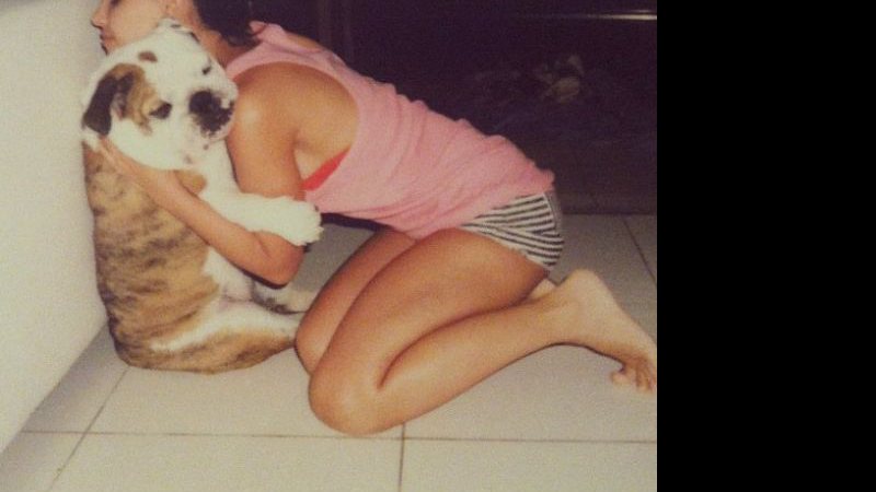 Imagem De camisola, Mariana Rios abraça cachorro